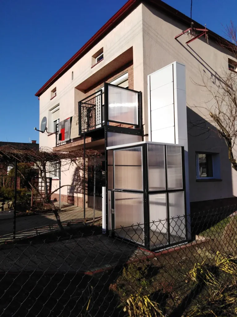 Winda dla niepełnosprawnych zamontowana zewnętrznie przy balkonie na wysokim parterze